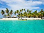 Tourists arriving at beautiful beach with crystal clear turquoise water.