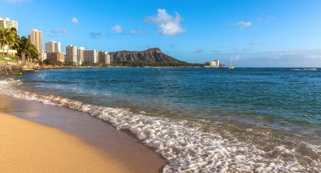 On the beach of Waikiki with Diamond Head Volcano in the background.