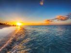 Grace Bay Beach, Turks & Caicos, with the setting sun at the horizon.