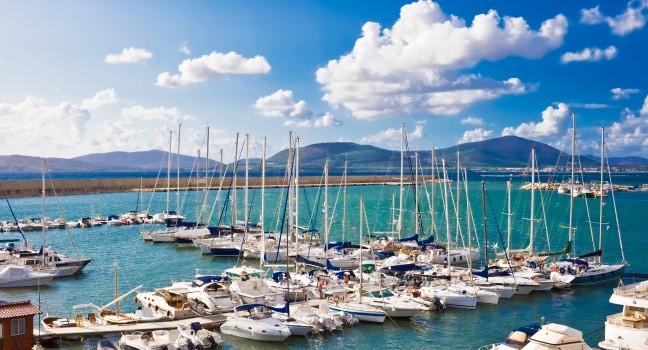 Classic white yachts anchored in the port of Alghero, Sardinia; 