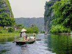 The woman is paddling groceries and fresh flowers boat. Tam Coc Grotto, Ninh Binh Province, Vietnam; Shutterstock ID 108993764; Project/Title: fodors.com destinations; Downloader: Melanie Marin