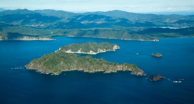 An ariel view of blue ocean water and Tortugas Islands in the Gulf of Nicoya, Costa Rica, Central America.