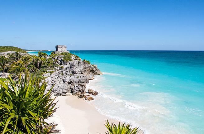 A view of the sugary beach and clear, blue water in Tulum