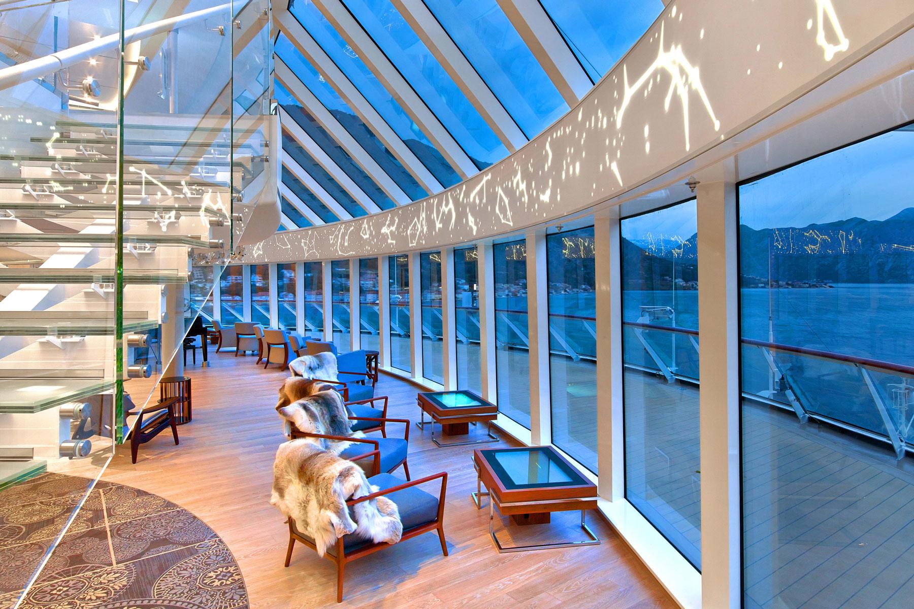08_FodorsEd_Luxurious_VikingSky_Explorers_Lounge_Windows_Stairs_Night_25