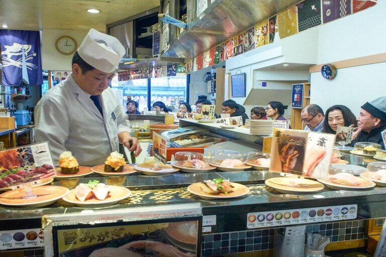 <a href='https://www.fodors.com/world/asia/japan/tokyo/experiences/news/photos/heres-how-to-save-money-when-you-visit-tokyo#'>From "Tokyo Is Expensive! So, Here Are 10 Ways to Save Money When You Visit: Choose Sushi Places Wisely"</a>